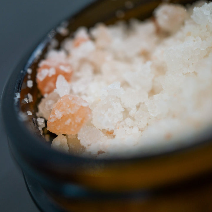 Close up of opened jar of pink and white bath salts