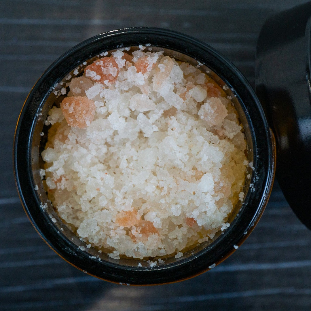 Opened jar of bath salts showing pink and white salt