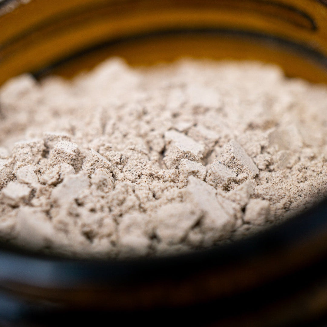 Close up image of clay powder in open amber jar