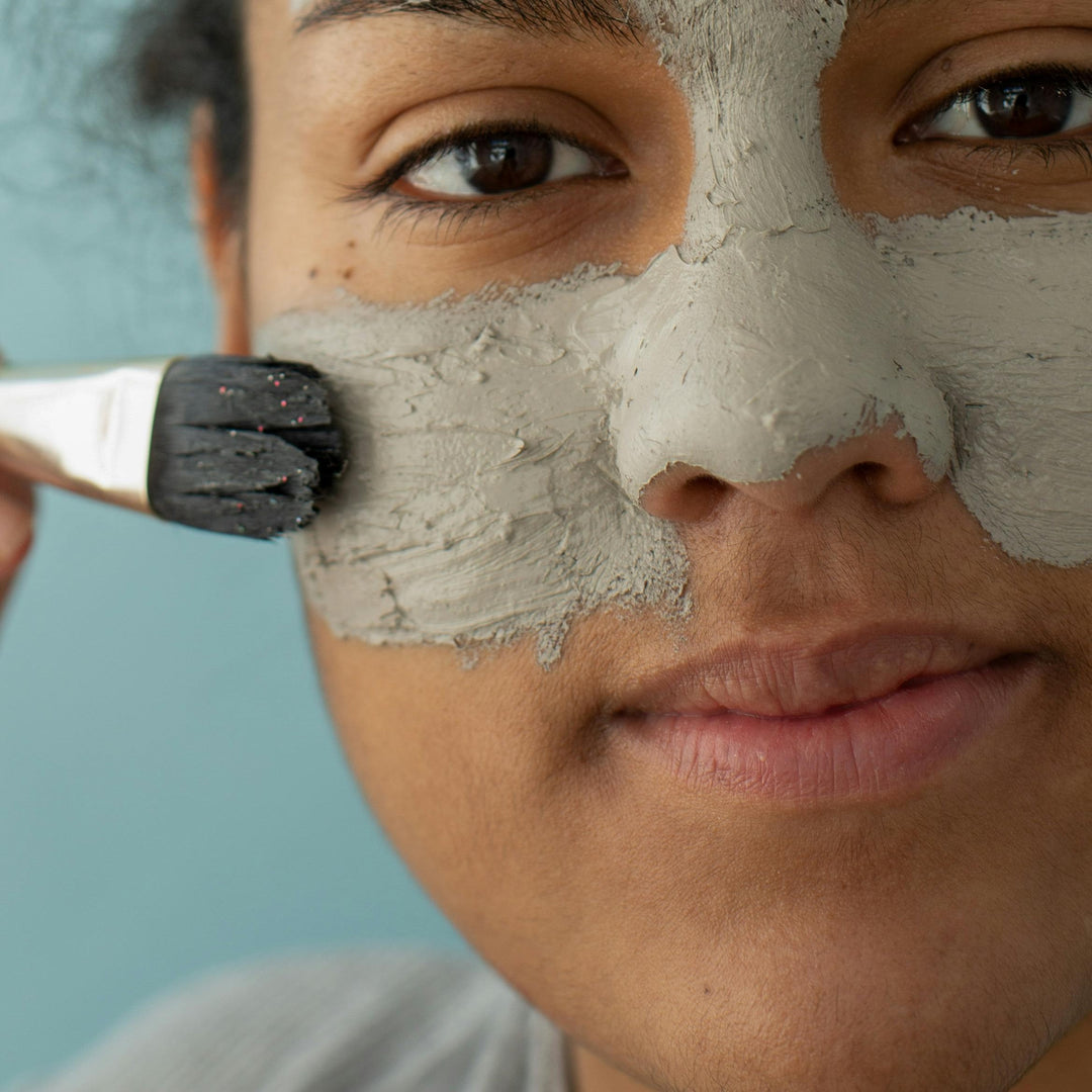 Girl applying green face mask